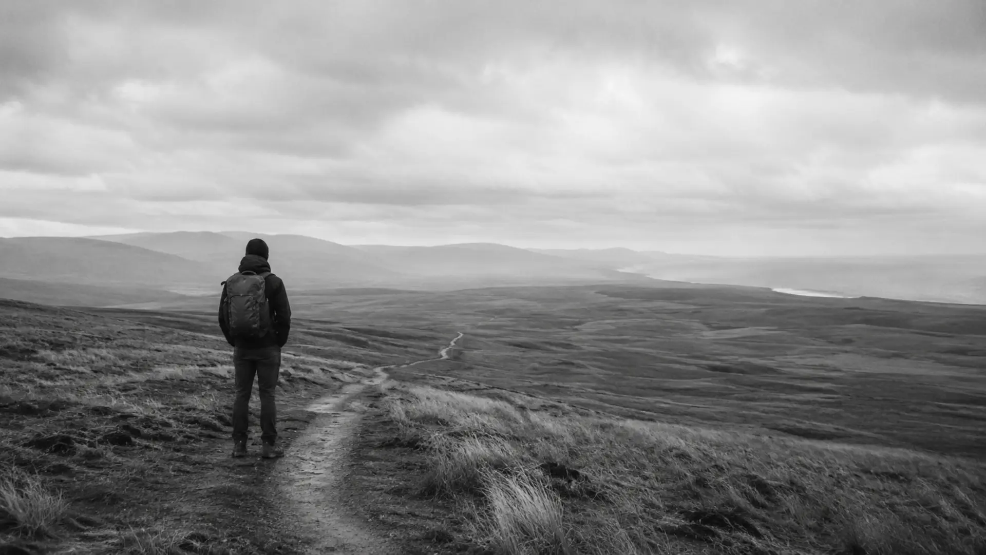 Viaggiatore solitario con zaino davanti a un paesaggio aperto